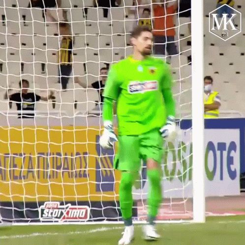 A Soccer Player In A Green Uniform Is Standing In Front Of A Net GIF