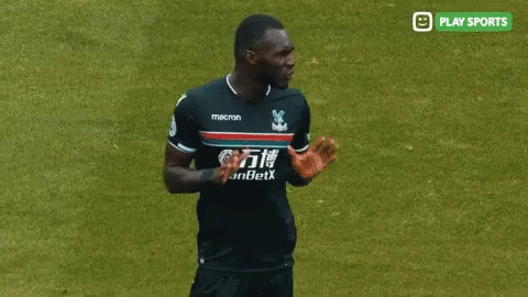a soccer player in a macron jersey talks to a referee