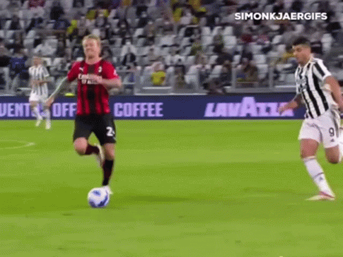 A Soccer Player In A Red And Black Jersey Is Running With The Ball GIF