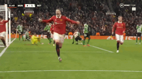 a soccer player in a red jersey runs on the field