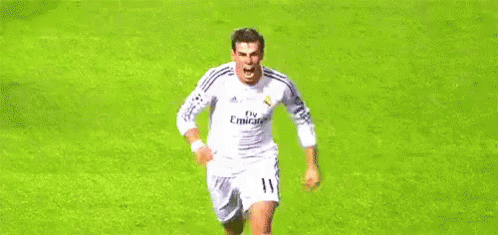 A Soccer Player In A White Jersey Is Running On A Soccer Field . GIF