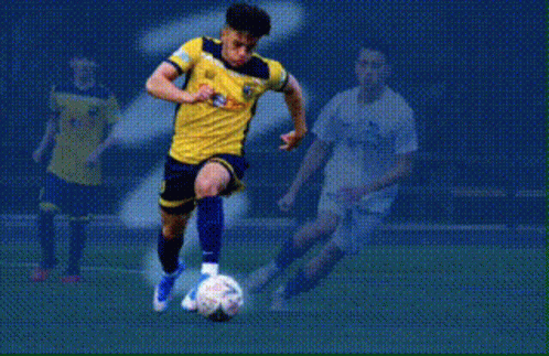 A Soccer Player In A Yellow And Blue Jersey Is Dribbling A Soccer Ball With The Word Fields Behind Him GIF