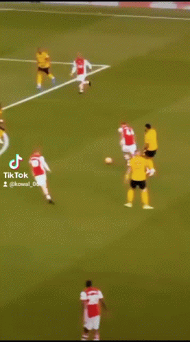 a soccer player in a yellow jersey is kicking a ball