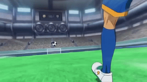 A Soccer Player In Blue Socks Is Kicking A Soccer Ball On A Field . GIF