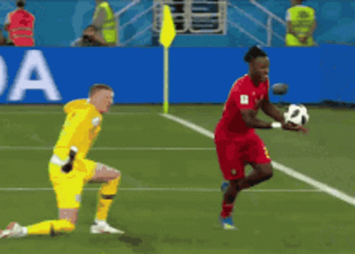 A Soccer Player In Red Runs Towards A Goal While A Goalie In Yellow Watches GIF