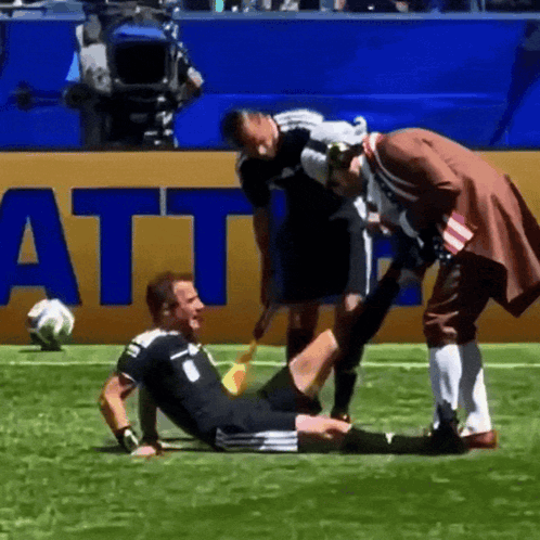 A Soccer Player Is Being Helped On The Field By A Man In A Pirate Outfit GIF