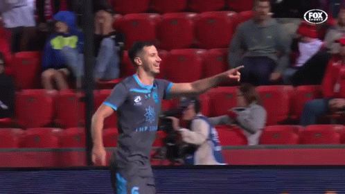 A Soccer Player Is Celebrating A Goal In Front Of A Crowd Of People . GIF