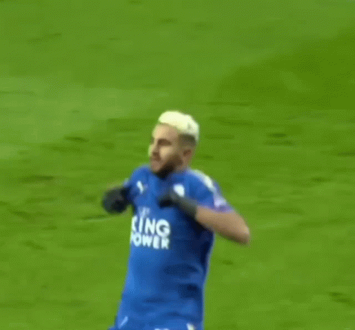 A Soccer Player Is Celebrating A Goal On A Field . GIF