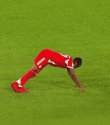 A Soccer Player Is Doing Push Ups On A Lush Green Field GIF