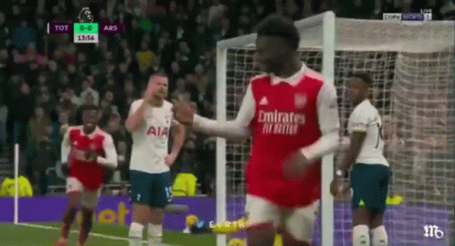 A Soccer Player Is Giving A High Five To Another Player On The Field . GIF