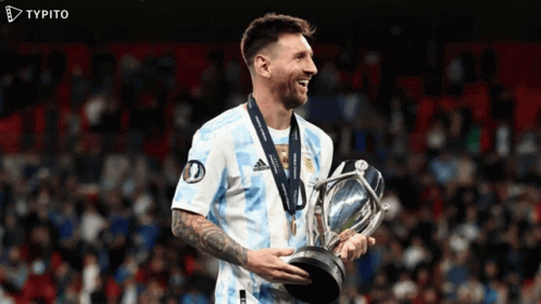a soccer player is holding a trophy and smiling with a typito logo in the background