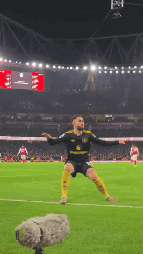 A Soccer Player Is Jumping In The Air On A Field With A Microphone Behind Him GIF