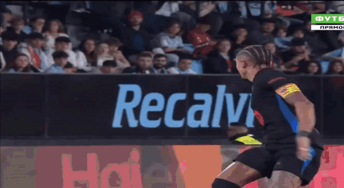 A Soccer Player Is Kicking A Ball In Front Of A Haier Sign GIF