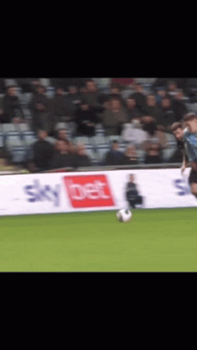 A Soccer Player Is Kicking A Ball In Front Of A Sky Bet Banner GIF
