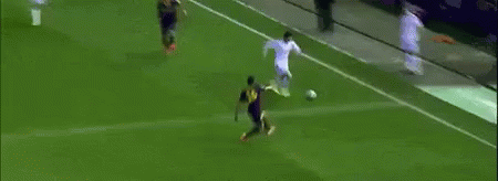 A Soccer Player Is Kicking A Ball Into The Goal While A Crowd Watches . GIF