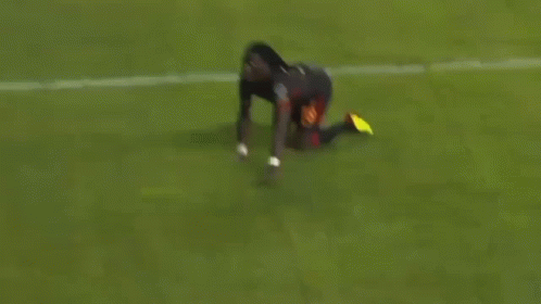 A Soccer Player Is Kneeling Down On The Field . GIF