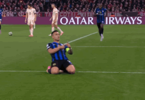 a soccer player is kneeling on the field in front of a qatar airways banner