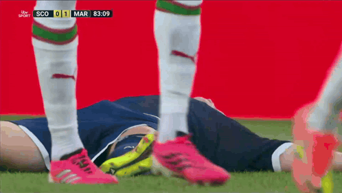 A Soccer Player Is Laying On The Ground During A Match Between Scotland And England GIF