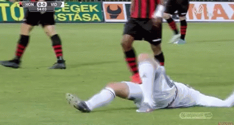 A Soccer Player Is Laying On The Ground With His Head Down GIF