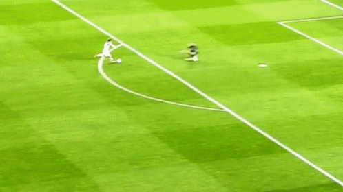 A Soccer Player Is Running Towards A Goal While Another Player Lays On The Ground . GIF