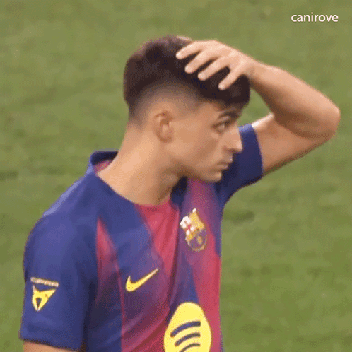 a soccer player is scratching his head with his hand while wearing a nike jersey .