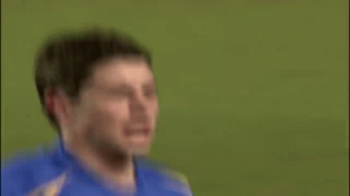 A Soccer Player Is Sitting On The Ground With A Playstation Sign In The Background GIF
