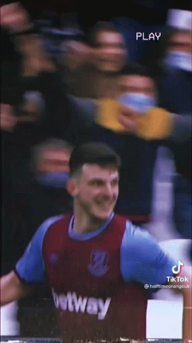 A Soccer Player Is Standing In Front Of A Crowd While Wearing A Purple And Blue Jersey . GIF