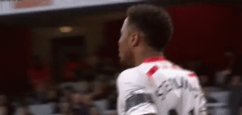 A Soccer Player Is Standing In Front Of A Crowd While Wearing A White Jersey With The Number 11 On It . GIF