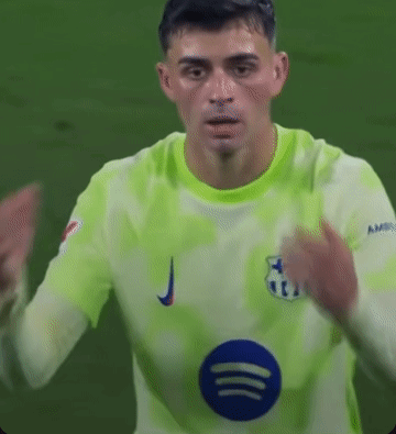 a soccer player is wearing a green jersey with a blue circle on the front .
