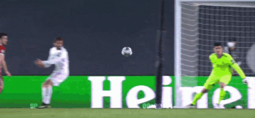 A Soccer Player Kicking A Ball In Front Of A Heineken Sign GIF