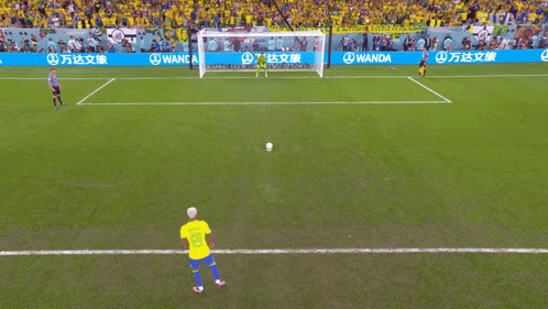 A Soccer Player Kicking A Ball In Front Of A Wanda Advertisement GIF