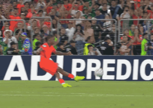 A Soccer Player Kicking A Ball In Front Of An Ad For Ad Predic GIF