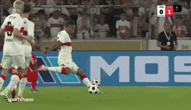 a soccer player kicking a soccer ball in front of a mos sign