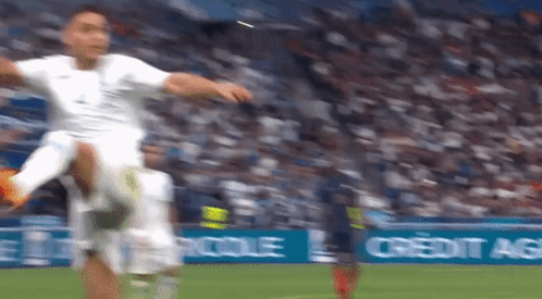 A Soccer Player Kicking A Soccer Ball On A Field With A Credit Agricole Banner In The Background GIF