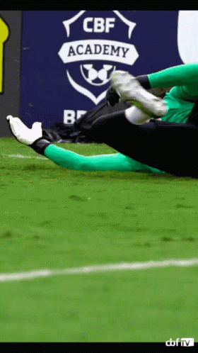 A Soccer Player Kicks A Ball In Front Of A Cbf Academy Sign GIF