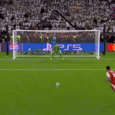 a soccer player kicks a ball in front of a ps5 banner