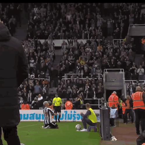 A Soccer Player Kneels On The Field In Front Of A Banner That Says ' Allianz ' GIF