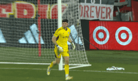 A Soccer Player Runs Towards A Goal With A Sign That Says Forever In The Background GIF
