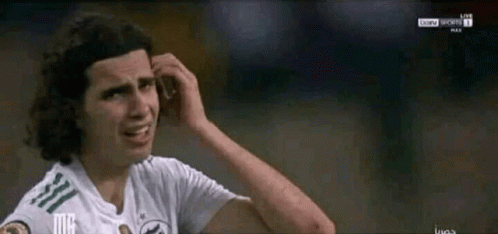 A Soccer Player Scratches His Head While Wearing A White Shirt GIF