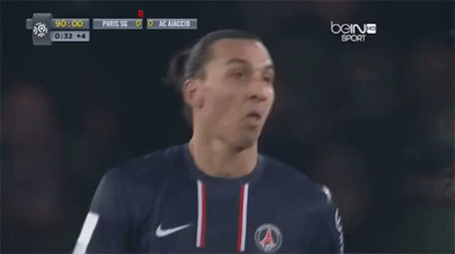 a soccer player stands in front of a bein sports screen