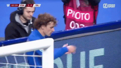A Soccer Player Stands In Front Of A Sign That Says Photo On It GIF