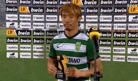 A Soccer Player Stands In Front Of A Wall With Bwin Advertisements GIF