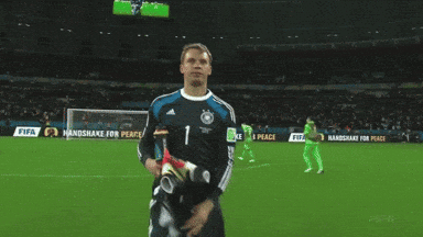 a soccer player stands on a field with a sign that says handshake for peace