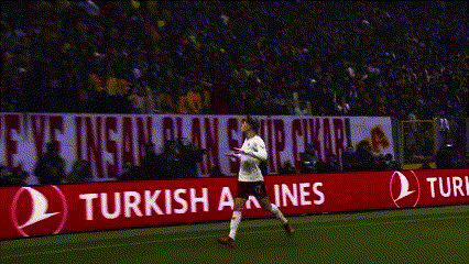 a soccer player stands on the field in front of a banner that says enjoy responsibly