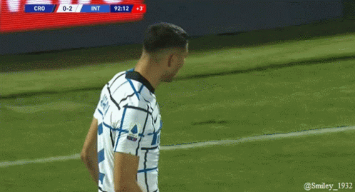 a soccer player stands on the field with the scoreboard showing cro 0-2