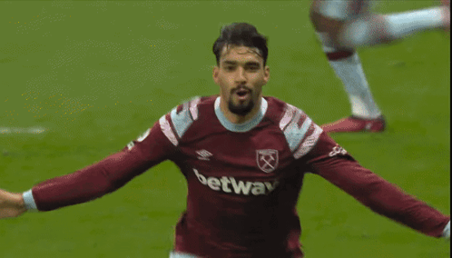 a soccer player wearing a betway jersey holds his head in his hands