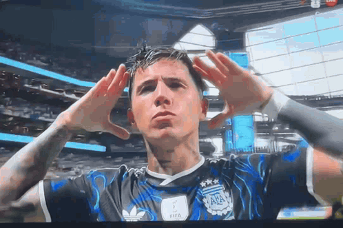 a soccer player wearing a black and blue adidas jersey