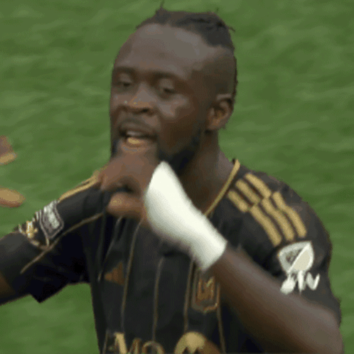 A Soccer Player Wearing A Black And Gold Jersey With The Letter M On It GIF