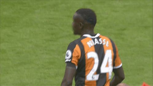 A Soccer Player Wearing A Black And Orange Jersey With The Number 24 On The Back GIF