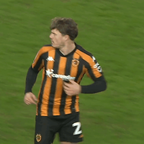 A Soccer Player Wearing A Black And Orange Striped Jersey With The Number 27 On The Back GIF